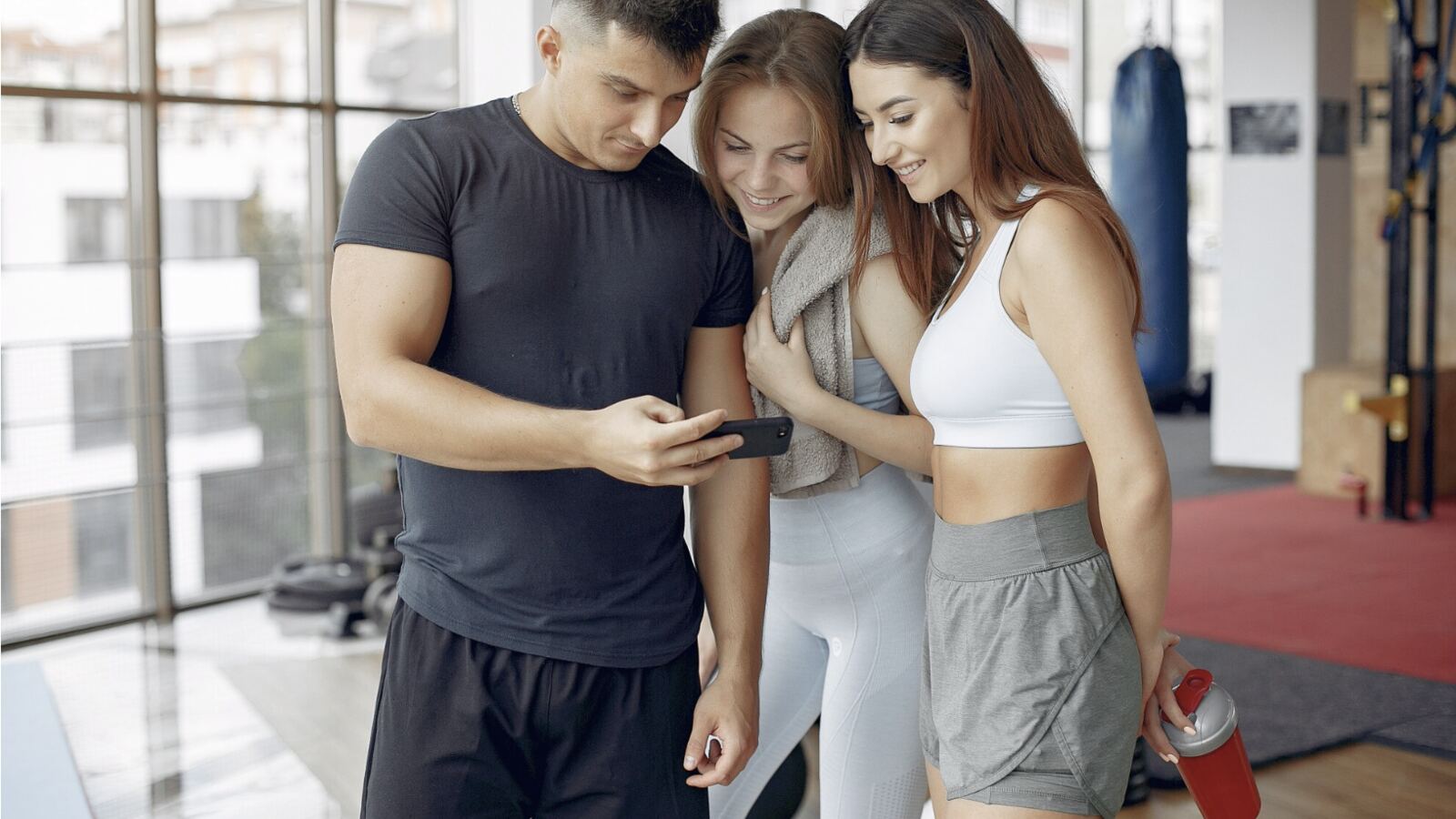Gym member checking the cult.fit app between sets — the moment the Smart Workout Plan was designed for.